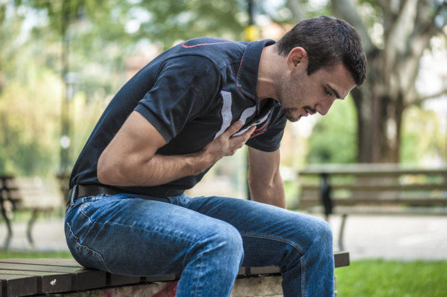 man having chest pains in the park