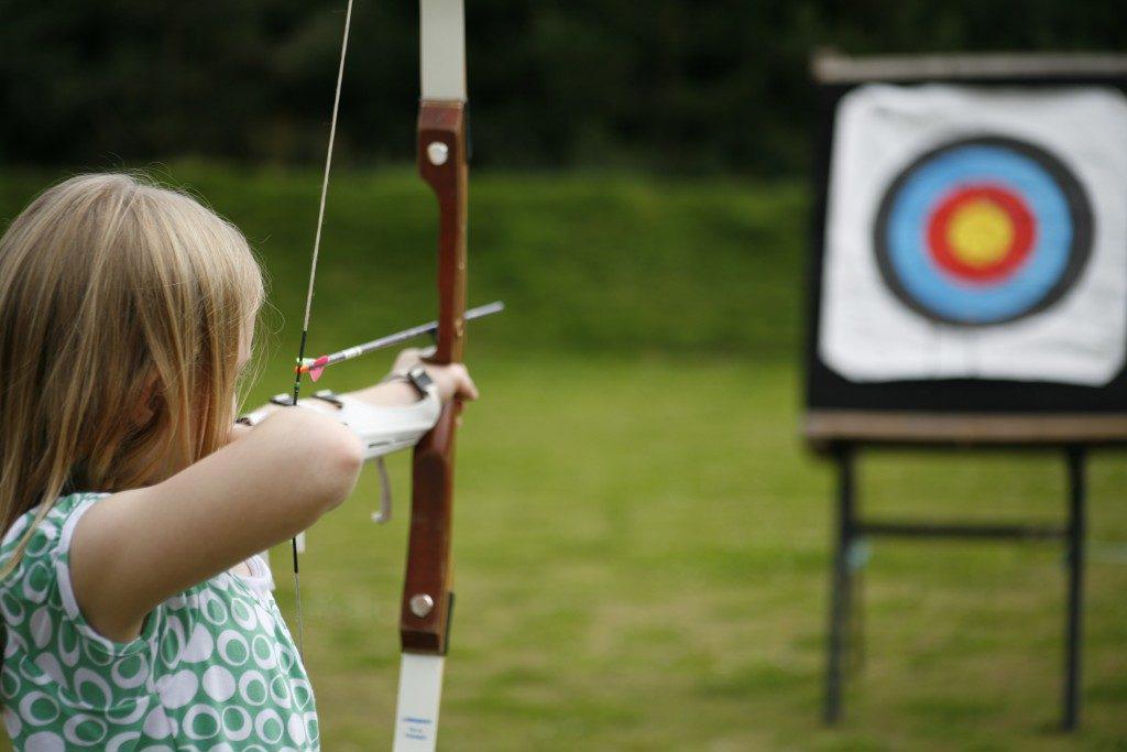 female archer aiming and getting ready to shoot