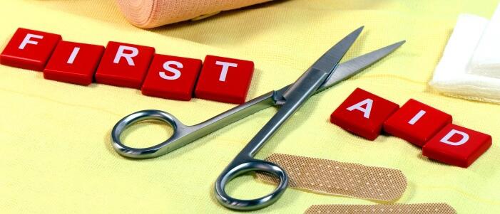 first aid in scrabble letters with first aid equipment on the table