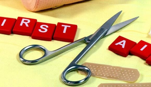 first aid in scrabble letters with first aid equipment on the table