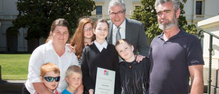 st john volunteer with award amongst family and friends