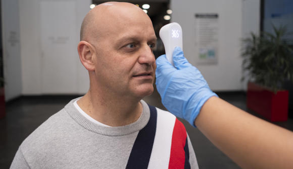 Man getting temperature screened at the office 