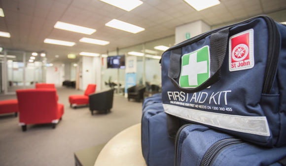 3 St John first aid kits stacked on a table in a room