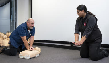 St John first aid training trainer with student on CPR manikin 
