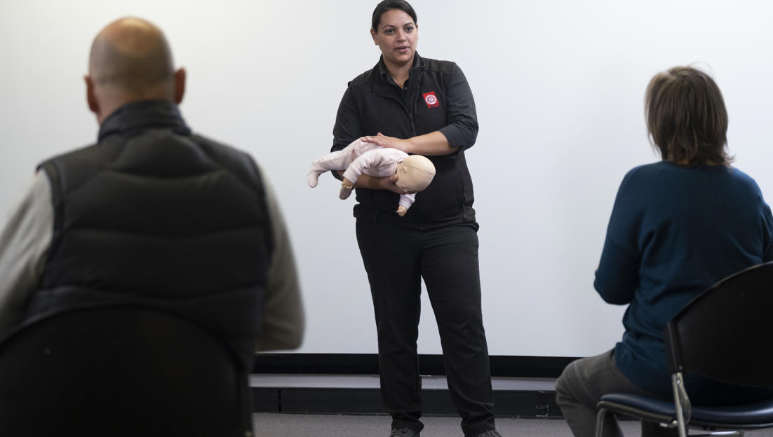 St John first aid training trainer with baby manikin