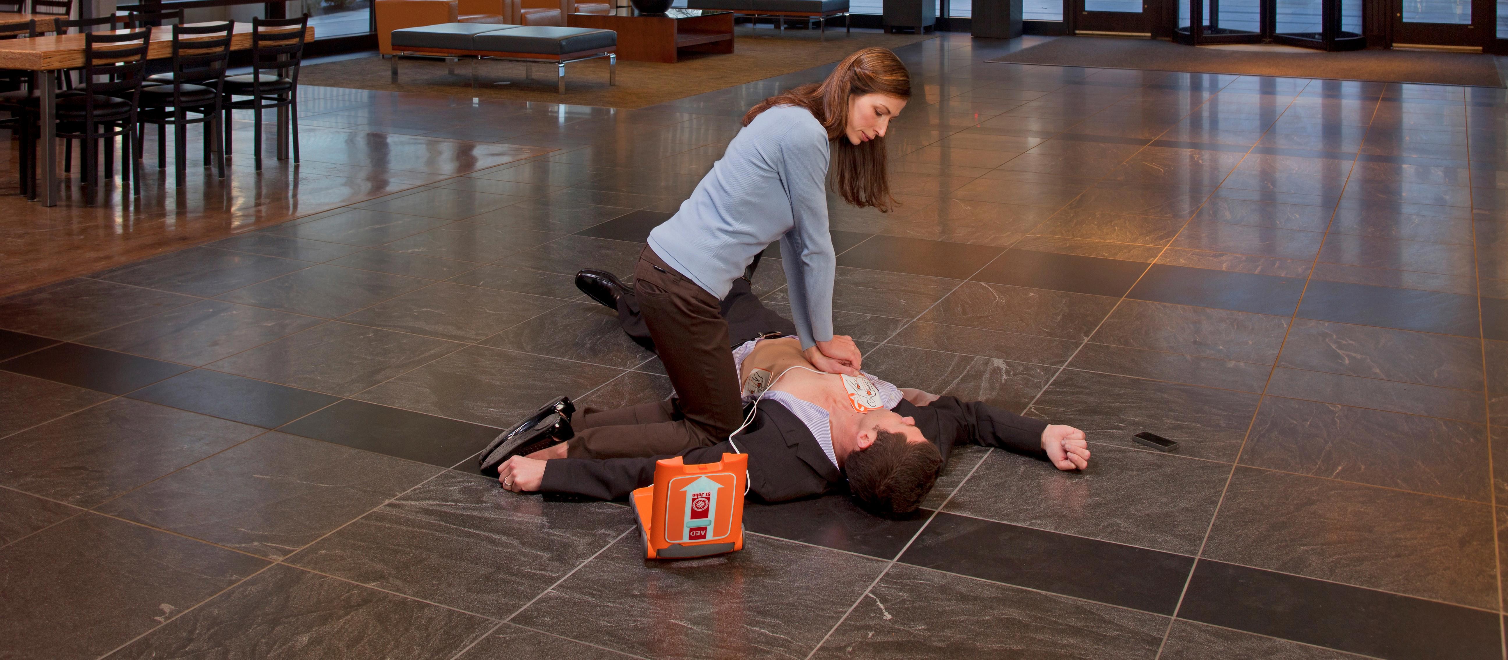 Person performing CPR with a St John defib 