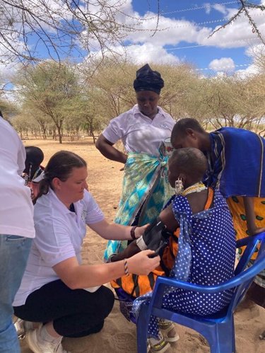 Caitlin helping a local in Tanzania by taking blood pressure