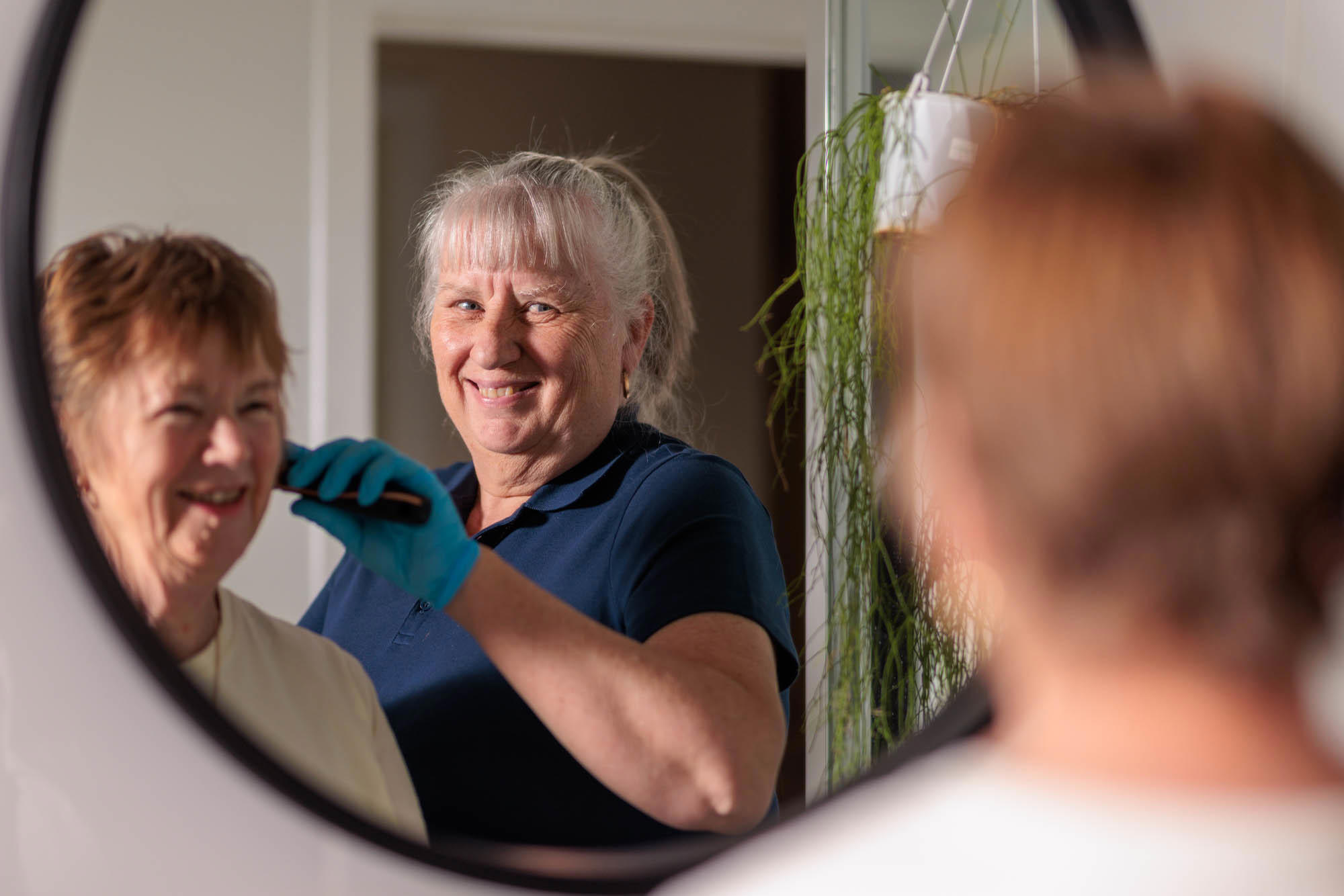 Carer brushing client's hair in the bathroom